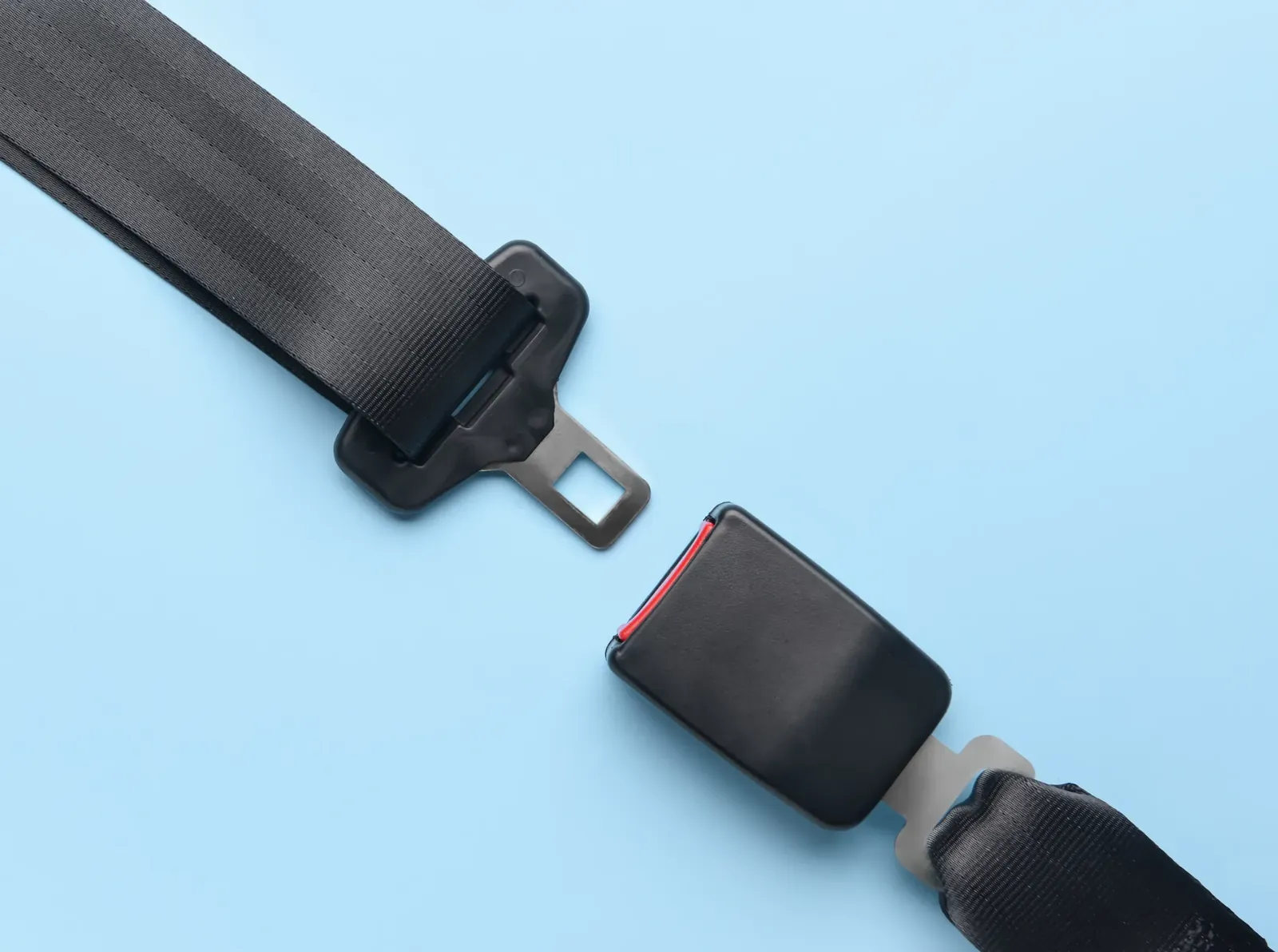 Seat belt buckle and webbing tongue shown as separate components against a plain light background.